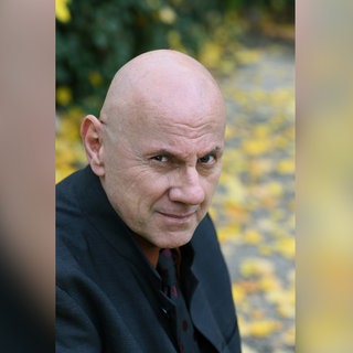Schriftsteller Andreas Pflüger schaut in die Kamera. | Schriftsteller Andreas Pflüger: Er ist der Meister des tief-recherchierten Thrillers