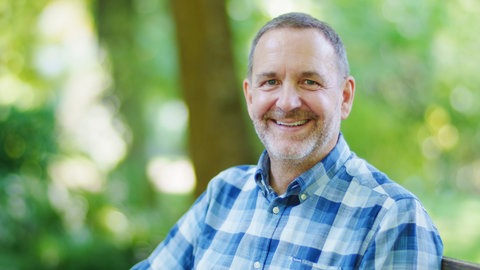 Gartenbauwissenschaftler Folko Kullmann sitzt im Grünen auf einer Bank. In SWR1 Leute spricht er über den Anbau von Obst und Gemüse im Garten, Hochbeet oder auf dem Balkon. Der Trend zur Selbstversorgung boomt.