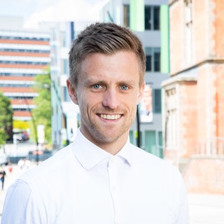 Patrick Kaczmarczyk blickt in die Kamera. Der Politökonom fordert ein Umdenken in der Wirtschaftspolitik zwischen Industriestaaten und dem globalen Süden. Er ist zu Gast in SWR1 Leute