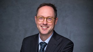 Politikwissenschaftler Prof. Andreas Fulda lacht in die Kamera. Die Rhetorik wird schärfer, die militärischen Muskelspiele werden heftiger: Was, wenn China Taiwan tatsächlich angreift? Wir sprechen in SWR1 Leute mit Politikwissenschaftler Prof. Andreas Fulda