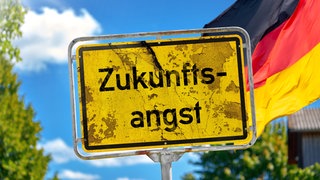 Fotomontage, Ein altes Schild mit der Aufschrift Zukunftsangst vor deutscher Flagge symbolisiert die wachsende Unsicherheit vieler Menschen. Die Nachhaltigkeitsforscherin Maike Sippel findet: Wir sollten selbst die Initiative ergreifen, statt auf Weichenstellungen der Politik zu warten. Sie ist Professorin für Nachhaltigkeit an der Uni Konstanz. Wie also kann ein Wandel gelingen? Wie können wir selbst initiativ werden und nicht nur warten, wann und wie die Politik handelt? Das besprechen wir mit Maike Sippel in SWR1 Leute.