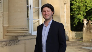 Lucas Reuter, Intendant Ludwigsburger Schlossfestspiele, schaut freundlich in die Kamera.