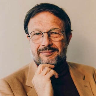 Palliativmediziner Prof. Gian Domenico Borasio hält die Hand an sein Kinn und schaut freundlich in die Kamera.   Was wissen wir heute über das Sterben und welche Mittel und Möglichkeiten haben wir, unsere Angst vor dem Tod zu mindern und uns auf das Lebensende vorzubereiten? Gian Domenico Borasio steht seit vielen Jahren für eine Medizin am Lebensende, die das Leiden Sterbender lindert und ihre Lebensqualität und die ihrer Angehörigen verbessern will. Palliativmediziner Gian Domenico Borasio ist zu Gast in SWR1 Leute.