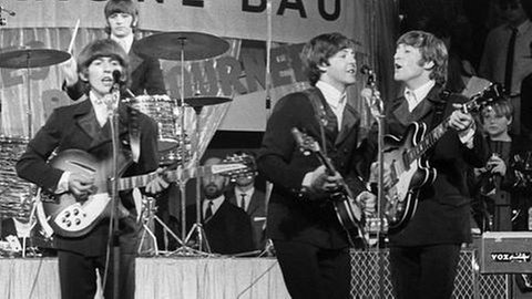 Mit Mitglieder der Beatles (vorne l. n. r.) George Harrison, Paul McCartney, John Lennon und hinten Drummer Ringo Starr bei einem Konzert in München