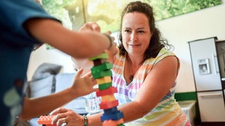 Tagesmutter spielt mit einem Kind