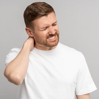 Mann mit Nackenschmerzen | Intensive Handynutzung: Was tun gegen Schmerzen in Nacken und Schultern?