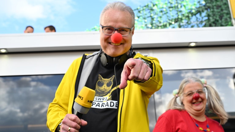 Die einzelnen Plätze in der Top 10 werden von besonderen Hitparaden-Gäste vorgestellt. Dazu gehörte auch Sylvia Siener von den Klinikclowns aus Koblenz. Sie hat Michael Lueg auch mal gleich mal eine rote Nase verpasst.