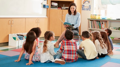 Eine Frau liest Kindern aus einem Buch vor | Aktion "Mehr Lesepaten für Rheinland-Pfalz"