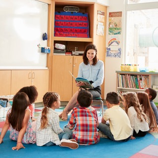 Eine Frau liest Kindern aus einem Buch vor | Aktion "Mehr Lesepaten für Rheinland-Pfalz"