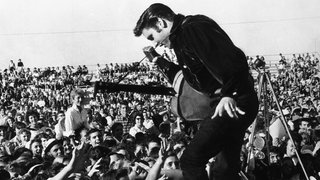 Elvis Presley bei einem Konzert Mitte der 50er-Jahre: Mit seiner Musik und dem lasziven Hüftschwung sorgte der King of Rock 'n' Roll für eine wahrhafte Hysterie.