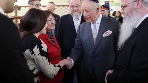König Charles III. trifft während seines Besuchs in der Synagoge der Hebräischen Gemeinde Heaton Park in Manchester Mitgliedern der Gemeinde.