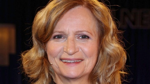 Johanna Gastdorf lacht mit offenen Haaren direkt in die Kamera.