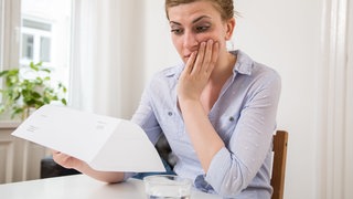 Abofallen: Eine Frau ließt eine Rechnung. Wo im Internet die Fallen lauern und wie man aus einer Abofalle wieder rauskommt. 