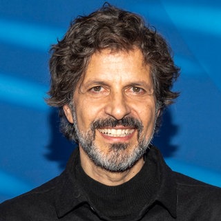 Der Schauspieler Pasquale Aleardi schaut lächelnd in die Kamera.