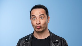 Der Comedian Bülent Ceylan schneidet eine Grimasse in die Kamera.