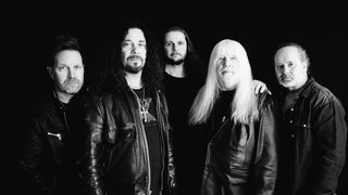 Die Band The Sweet stehen vor schwarzen Hintergrund und schauen in die Kamera