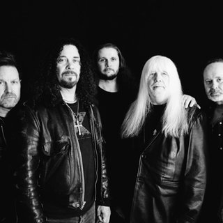 Die Band The Sweet stehen vor schwarzen Hintergrund und schauen in die Kamera