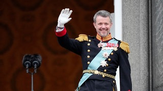 Dänemarks König Frederik X. winkt vom Balkon des Schlosses Christiansborg.
