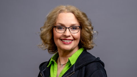 Porträt von SWR4 Moderatorin Sabine Gronau in grünem Polo und schwarzer Jacke