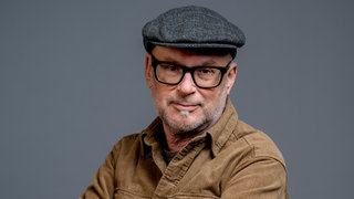 Porträt von SWR4 Moderator Stefan Nink mit grauem Hut und brauner Jacke