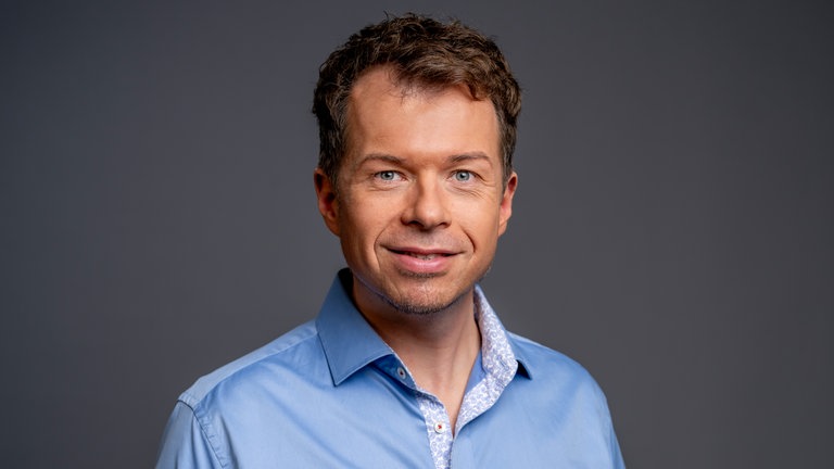 Porträt des SWR4 Moderators Daniel Pesch im hellblauen Hemd