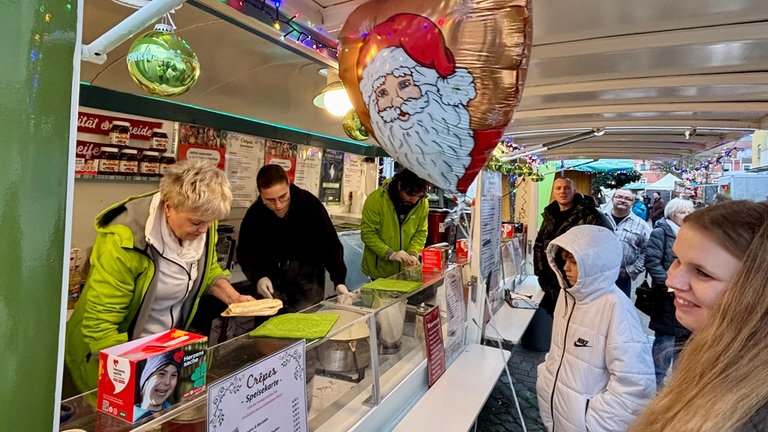 Weihnachtsmarkt in Ramstein: Eine Mutter und ihr kleiner Sohn warten beim SWR4 Adventsmobil auf ihre Bestellung.