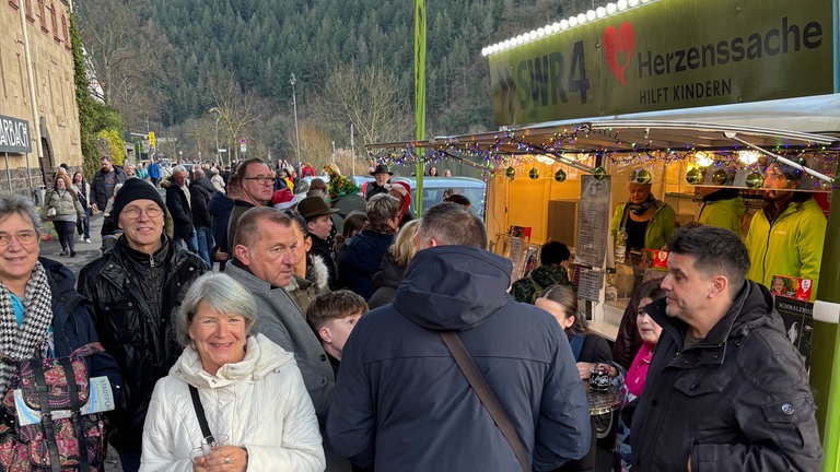 Das grüne Adventsmobil ist umringt von Besuchern. 