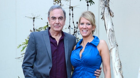 Sänger und Musiker Neil Diamond mit seiner Ehefrau Katie McNeil. Er trägt einen Anzug, sie ein schickes blaues Kleid.