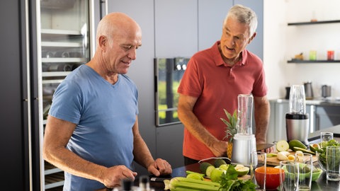 WG-Leben: Zwei Senioren kochen gemeinsam in der Küche ihrer Wohngemeinschaft.