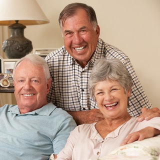Senioren auf einem Sofa in ihrer WG: Die Renterinnen leben und lachen zusammen.
