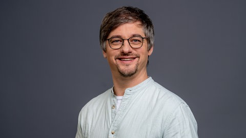 Porträt von SWR4 Redakteur Oliver Schönfeld im hellgrauen Hemd