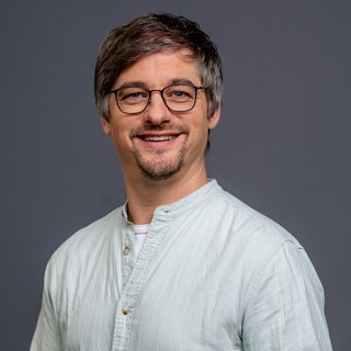 Porträt von SWR4 Redakteur Oliver Schönfeld im hellgrauen Hemd