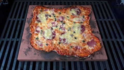 Eine Pizza auf einem Pizzastein gebacken.