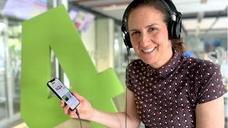 Die SWR4 App in ARD Sounds hat den schönsten Musikmix für den Tag: Moderatorin Chrissie Weiss hört SWR4 auf dem Smartphone mit Kopfhörer.