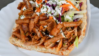 Ein Döner mit Brot, Fleisch, Jogurt, Karotten und Kraut.