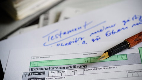 Das Formular für die Erbschaftssteuererklärung liegt auf einem Testament