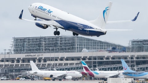 Ein Flugzeug der Fluggesellschaft Blue Air startet am Flughafen Stuttgart, dahinter ist Terminal 1 des Flughafens zu sehen.
