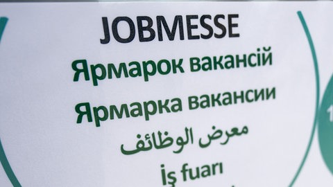Ein Schild mit der Aufschrift Jobmesse in verschiedenen Sprachen