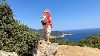 Ein Tourist geht bei wolkenlosen Himmel auf der griechischen Insel Skopelos wandern. Spaß und Abenteuer sind den Deutschen im Urlaub wichtiger als Erholung.