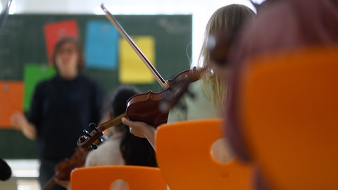 Eine Schülerin spielt Geige im Musikunterricht.