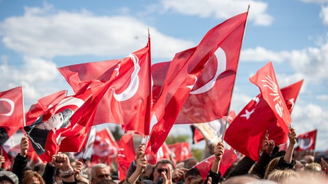 Menschen halten türkische Flaggen während einer Demonstration.