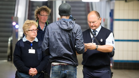 Kontrolleure überprüfen am Ausgang einer U-Bahn Station die Fahrscheine von Reisenden.