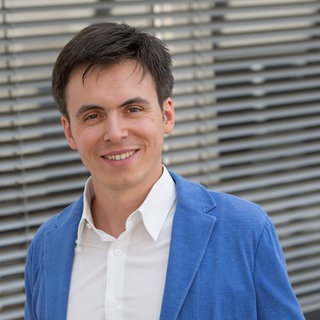 Sebastian Felser steht im Gang eines SWR-Gebäudes. 