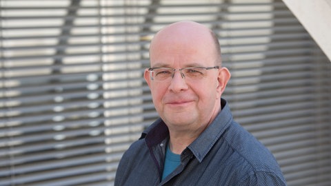 Stefan Eich steht im Gang eines SWR-Gebäudes.