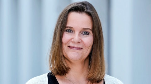 Constance Schirra steht im Gang eines SWR-Gebäudes