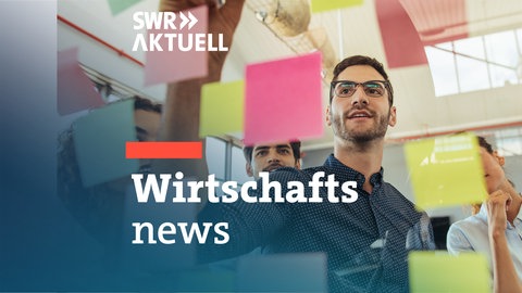Ein junges Team plant ein Geschäftsvorhaben mit bunten "Post it"-Zetteln.