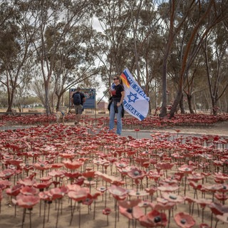 Eine Frau mit einer israelischen und einer deutschen Flagge steht auf dem Nova-Festivalgelände in Re'im vor dem zweiten Jahrestag des von der Hamas verübten Anschlags vom 7. Oktober