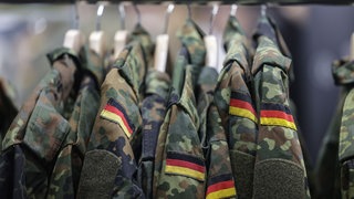 Feldjacken hängen am Stand der Bundeswehr bei der Computerspiele-Messe Gamescom.