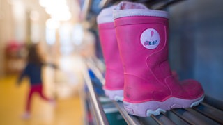Gummistiefel stehen in einer Kindertagesstätte.