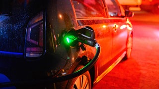 Ein Elektroauto Volkswagen e-up! lädt an einer öffentlichen Schnellladesäule.